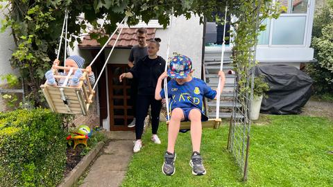 Igor und Natascha Wiebe mit ihren Söhnen Alexander (6) und Alessio (9 Monate) - beide Jungs schaukeln hinter dem Haus.