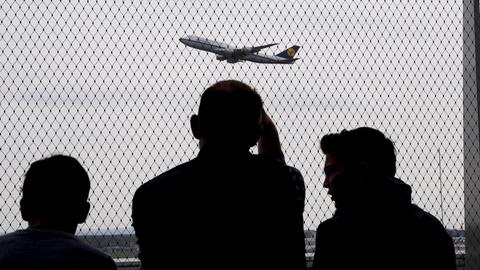 Menschen beobachten einen Start am Flughafen