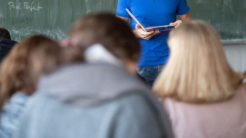  Ein Lehrer unterrichtet in einem Klassenzimmer.