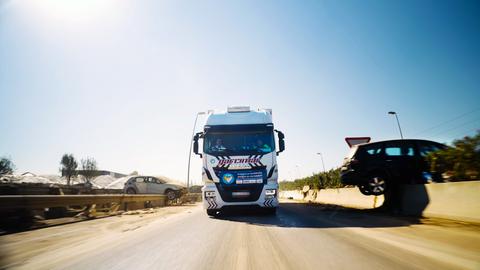 Der LKW einer deutschen Hilforganisation auf einer spanischen Autobahn. Links und rechts liegen Autowracks.