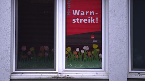  Im Fenster einer Kindertagesstätte hängt ein Plakat mit der Aufschrift "Warnstreik".