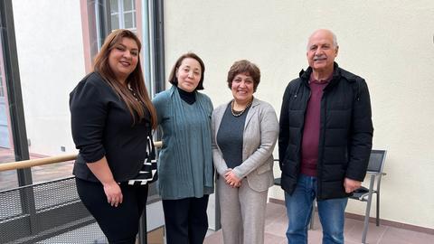 Drei Frauen und ein Mann stehen nebeneinander