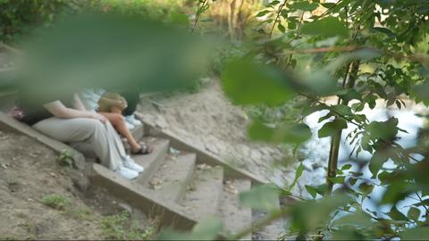 Drei Frauen sitzen auf einer Treppe an einem Fluss