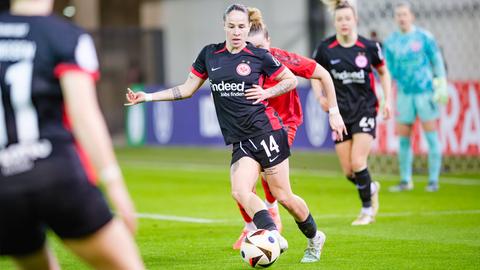 Geraldine Reuteler (schwarzes Eintracht-Trikot) spielt einen Pass mit ihrem rechten Fuß. 