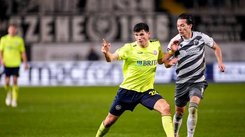 Moritz Flotho (im neongelben SVWW-Trikot) im Zweikampf mit Jeremias Lorch (im schwarz-weiß gestreiften Sandhausen-Trikot).