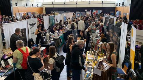 Blick in die Messehalle mit Ständen und Besuchern