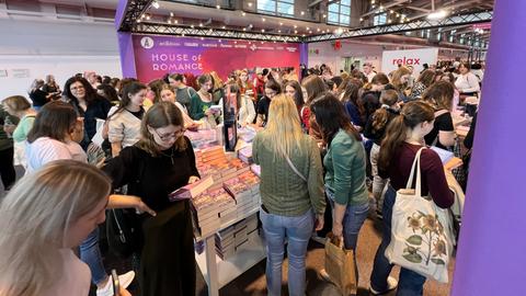 Das Bild zeigt dichtes Gedränge im New-Adult-Bereich auf der Buchmesse 2024. Hauptsächlich junge Frauen stehen dicht gedrängt um einen Tisch mit Büchern.