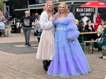 Das Bild zeigt zwei Cosplayerinnen auf der Buchmesse 2024: Die beiden Frauen tragen opulente Prinzessinenkleider in Lila und Weiß.