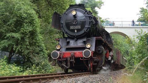 Eine Dampflok auf Eisenbahnschienen. 