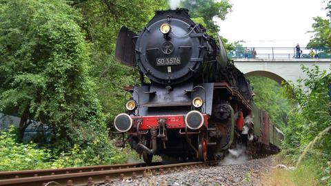 Eine Dampflok auf Eisenbahnschienen. 