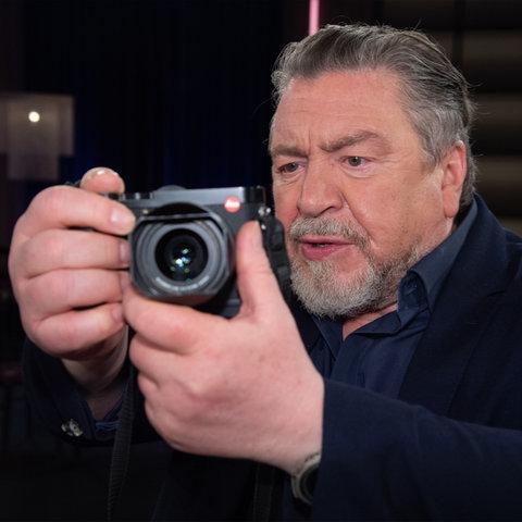 Schauspieler und Fotograf Armin Rohde mit Kamera.