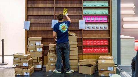 Das Bild zeigt einen Mann im T-Shirt von hinten. Er räumt Bücher in ein Regal auf der Frankfurter Buchmesse.