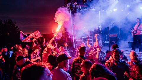 Fans mit Pyrotechnik vor der Bühne