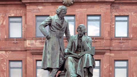 Das Brüder-Grimm-Denkmal von 1896 mit Wilhelm Grimm sitzend und Jacob Grimm stehend, aufgenommen am 02.09.2015 vor dem historischen Rathaus auf dem Marktplatz in Hanau 