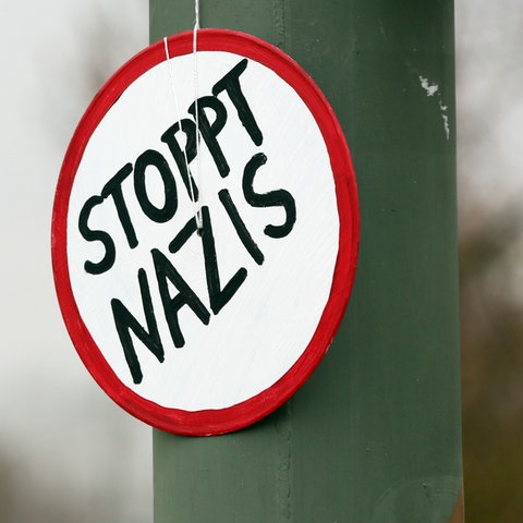 Schild mit der Aufschrift "Stoppt Nazis"
