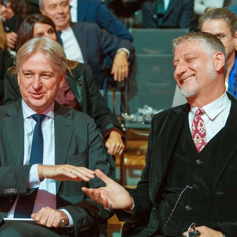 Buchmesse-Direktor Juergen Boos (links) sitzt bei der Eröffnungsfeier neben Alessandro Giuli, Kulturminister von Italien.