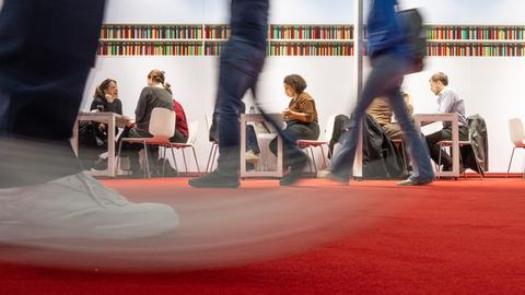 Besucher gehen an einem Fachbesuchertag über die Frankfurter Buchmesse.