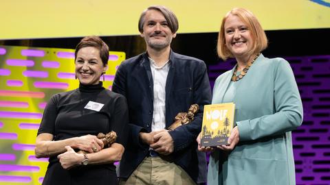 Sasa Stanisic und die Illustratorin Regina Kehn (links) nehmen den Jugendliteraturpreis für ihr Kinderbuch "Wolf" von Bundesfamilienministerin Lisa Paus (Grüne) entgegen. 