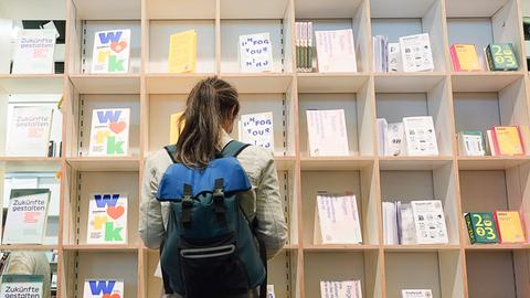 Eine Besucherin schaut sich auf der Frankfurter Buchmesse an einem Stand Bücher an. 