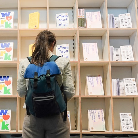 Eine Besucherin schaut sich auf der Frankfurter Buchmesse an einem Stand Bücher an. 