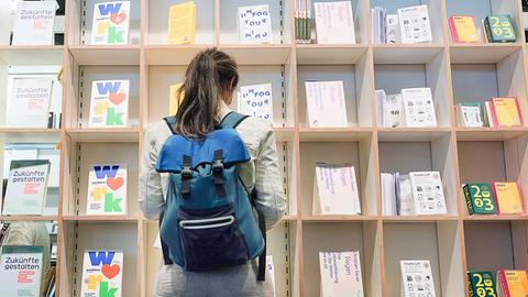 Eine Besucherin schaut sich auf der Frankfurter Buchmesse an einem Stand Bücher an. 