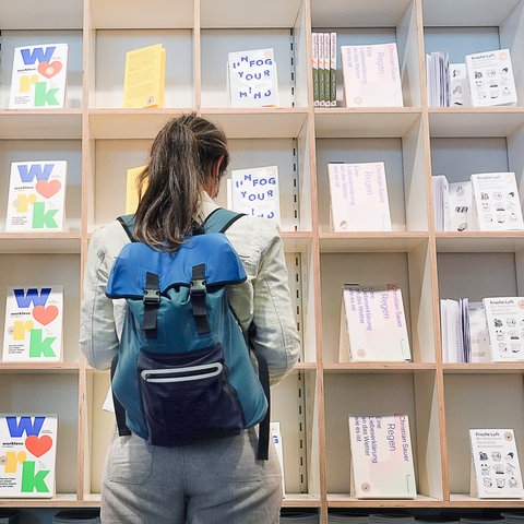 Eine Besucherin schaut sich auf der Frankfurter Buchmesse an einem Stand Bücher an. 