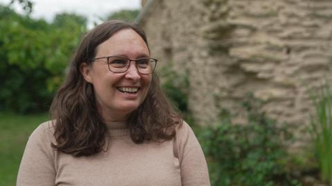 Burgbesitzerin Lauren Liss mit braunen, langen Haaren und Brille lächelt in die Kamera