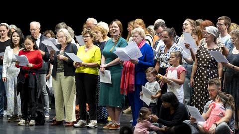 Mehrer Dutzend Menschen unterschiedlichen Alters singen zusammen.