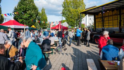 Menschen auf einem Dorffest, im Hintergrund eine kleine Bühne