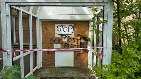 Das Bild zeigt den Eingang der leerstehenden ehemaligen ESOC-Bodenstation in Michelstadt. Die Tür ist mit einem Korkbrett vernagelt, davor ist ein rot-weißes Absperrband gespannt. An der Tür steht: Stop! Kein Lost Place.