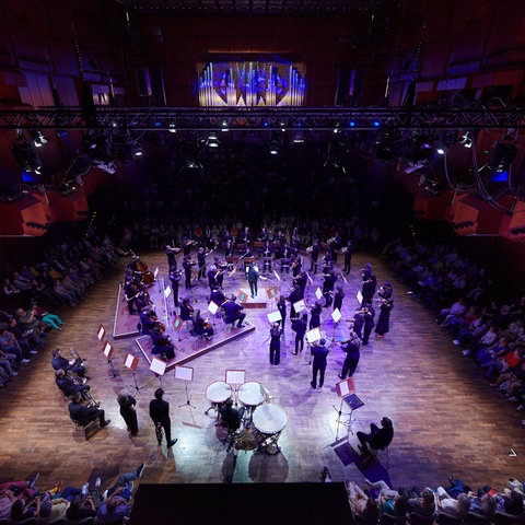 Klassisches Orchester, umringt von Publikum.