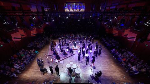 Klassisches Orchester, umringt von Publikum.