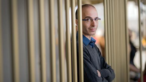 Yuval Noah Harari ist mit verschränkten Armen zu sehen. 