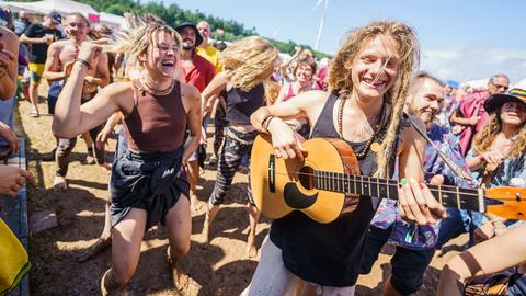 Herzberg-Festival: Menschen im Publikum, einer mit Gitarre, tanzen und singen.