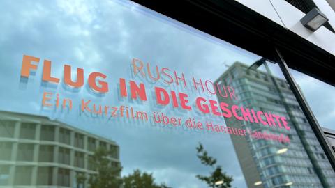 Schriftzug "Rush Hour, Flug in die Geschichte" auf einer Fensterscheibe