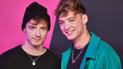 Heiko und Roman Lochmann vor einer pink-schwarten Wand. Einer trägt eine Mütze, der andere hat Locken. 