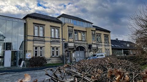 Das Gebäude des Museums für Sepulkralkultur ist ein gelber Backsteinbau aus den Anfängen des 20. Jahrhunderts. Links ist ein Anbau mit einer Glasfassade zu sehen.