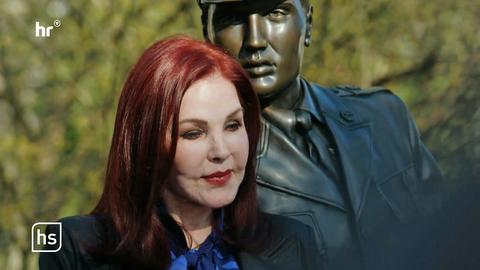 Rothaarige Frau vor der Bronzestatue von Elvis