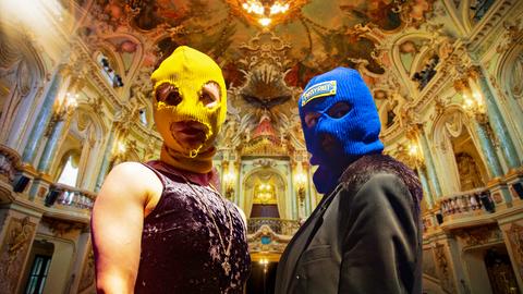 Cololage: Zwei maskierte Frauen im barocken Foyer des Staatstheaters
