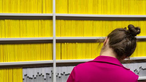 Eine Frau vor einem Regal mit lauter gelben Buchrücken