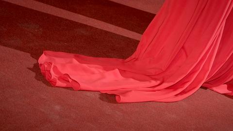 Ein roter Kleidzipfel eiens Abendkleids auf dem roten Teppich des hessischen Filmpreis