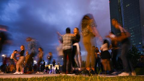 Tänzer in der Abend-Dämmerung, im Hintergrund das Hochhaus der EZB.