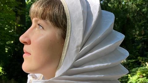 Frau mit faltbarem Sonnenschutz, der Sonnenenergie speichern kann. 