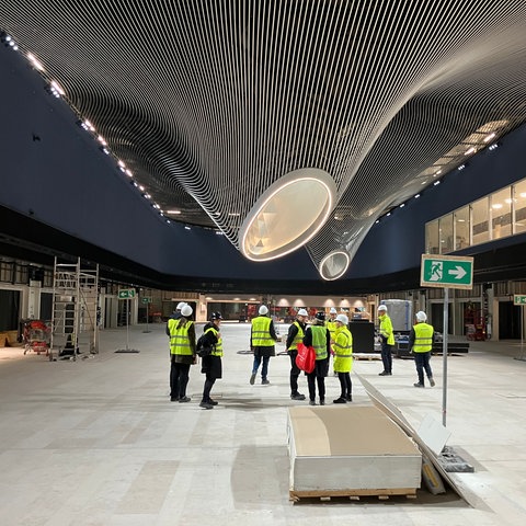 Menschen in neonfarbenen Schutzwesten auf der Baustelle