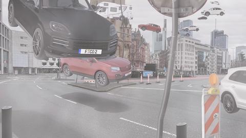 Das Bild zeigt eine Animation vom Eschenheimer Tor. Zu sehen sind verschiedene Autos und Straßenschilder, die an dem Verkehrsknotenpunkt in Frankfurt durch die Luft fliegen.