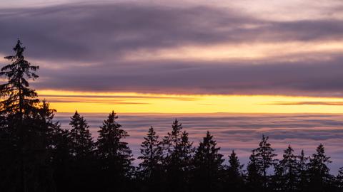 Der Gipfel des Glaskopfs ragt am Abend nach Sonnenuntergang aus dem Nebel.