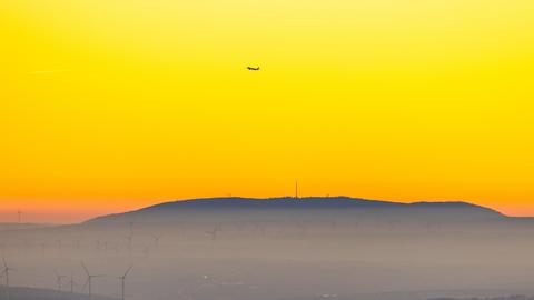 Ausblick vom Altkönig im Taunus bei Sonnenuntergang zum Donnersberg in Rheinland-Pfalz, dessen Gipfel zu sehen ist.