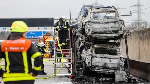 Feuerwehrleute an ausgebranntem Autotransporter auf A3