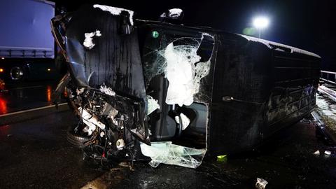 Ein Auto liegt beschädigt auf der Seite auf der Autobahn