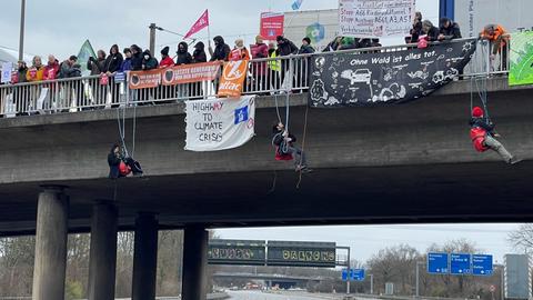 Demonstranten seilen sich an der A648 in Frankfurt ab.